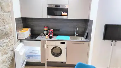 a small kitchen with a washing machine and a sink at hypercentre lamartine 001 in Nice