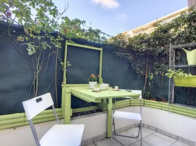 a green table and chairs on a balcony with plants at Nestor&Jeeves - MARYLIN - Central - Very close sea in Nice