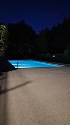 a large blue swimming pool at night at HOME ET HOLIDAY Le Petit Manseng in Nice