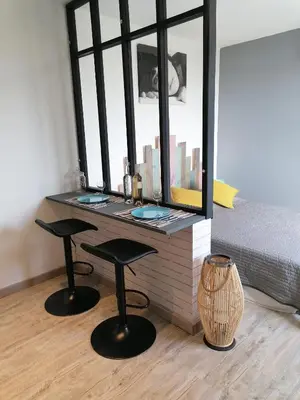a desk with two stools in front of a window at Studio Anoe in Nice