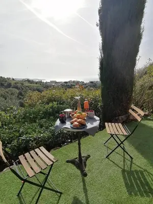 a table with a plate of food and two chairs at Studio Anoe in Nice