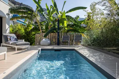 a swimming pool in a backyard with a deck and chairs at GROUND FLOOR VILLA GRAZIELLA 200 M FROM THE BEACH in Èze