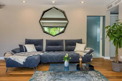 a living room with a blue couch and a mirror at GROUND FLOOR VILLA GRAZIELLA 200 M FROM THE BEACH in Èze