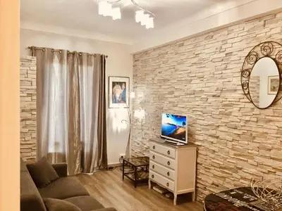 a living room with a stone wall at Studio Bel Air FSHH in Nice