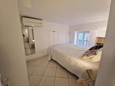 a bedroom with a large bed and a mirror at Le Cosy - Place Masséna in Nice
