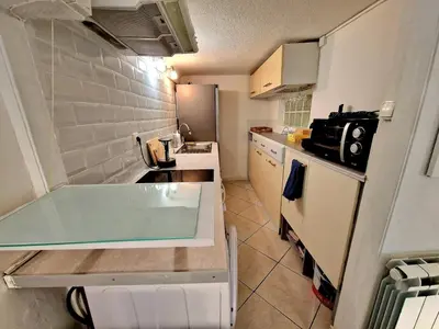 a small kitchen with a sink and a counter top at Le Cosy - Place Masséna in Nice