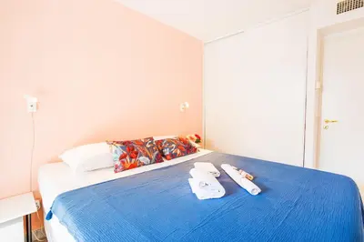 a bedroom with a blue bed with towels on it at PALAIS LIBERTE V AP4267 By Riviera Holiday Homes in Nice