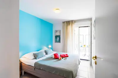 a bedroom with blue walls and a bed with red pillows at PALAIS LIBERTE V AP4267 By Riviera Holiday Homes in Nice