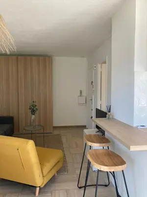 a living room with a yellow couch and a table at Habana in Saint-Laurent-du-Var