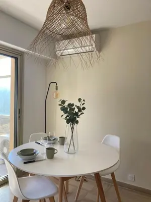 a white dining room with a white table and chairs at Habana in Saint-Laurent-du-Var