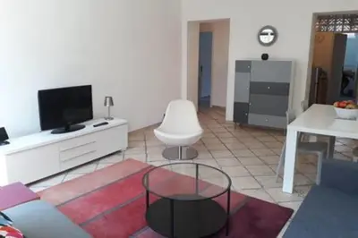 a living room with a couch and a tv and a table at Spacious Appartment Wifi Next To The Port in Nice