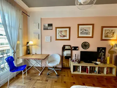 a living room with a desk and a table with a computer at Seaside vintage studio in Nice