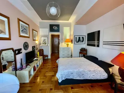 a bedroom with a bed and a television in it at Seaside vintage studio in Nice