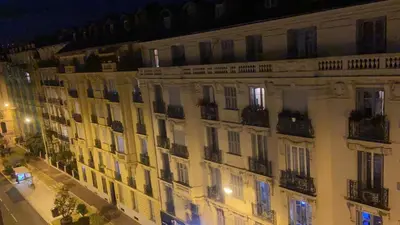 a large building with windows and balconies at night at Seaside vintage studio in Nice