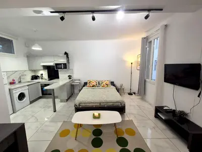 a living room with a bed and a kitchen at Studio rénové au centre ville (15 min de la plage) in Nice
