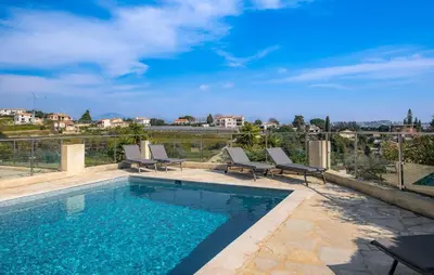 a swimming pool with lounge chairs next to at Lovely Home In Saint-Laurent-Du-Var in Saint-Laurent-du-Var