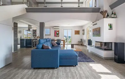 a living room with a blue couch and a fireplace at Lovely Home In Saint-Laurent-Du-Var in Saint-Laurent-du-Var
