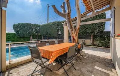 a table and chairs on a patio with a pool at Lovely Home In Saint-Laurent-Du-Var in Saint-Laurent-du-Var