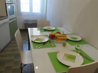 a table with plates of food and a bowl of fruit at Appartement du Thiers in Nice