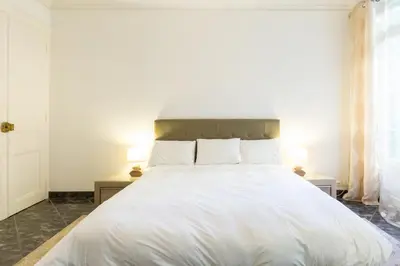 a bedroom with a large white bed with two lamps at Appartement du Thiers in Nice