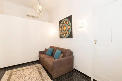 a living room with a brown chair with blue pillows at Appartement du Thiers in Nice