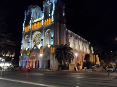 a large building with a clock tower at night at Appartement du Thiers in Nice