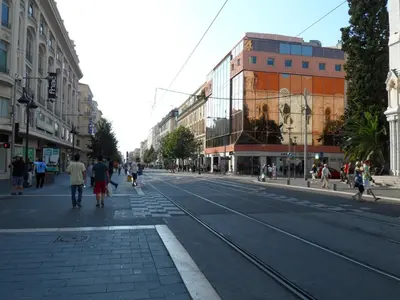 a busy city street with people walking down the street at Appartement du Thiers in Nice