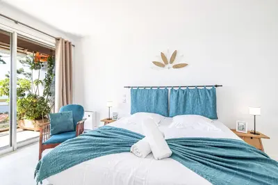 a bedroom with a bed and a blue chair at Extraordinary Sea View - 1 Bdr with AC in Villefranche-sur-Mer