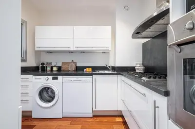 a kitchen with white cabinets and a washer and dryer at Extraordinary Sea View - 1 Bdr with AC in Villefranche-sur-Mer