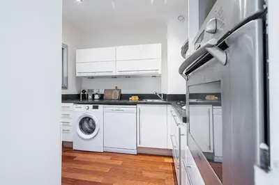 a kitchen with white cabinets and a washer and dryer at Extraordinary Sea View - 1 Bdr with AC in Villefranche-sur-Mer