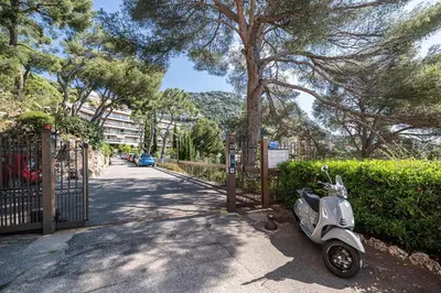 a scooter parked on a sidewalk next to a fence at Extraordinary Sea View - 1 Bdr with AC in Villefranche-sur-Mer