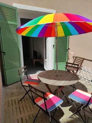 a table and chairs with a colorful umbrella at Villa Le Rêve in Nice