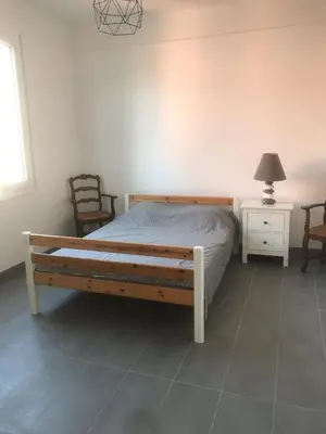 a bedroom with a wooden bed and two chairs at Villa Le Rêve in Nice