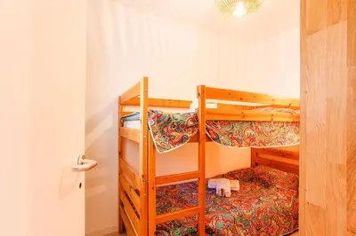 two bunk beds in a small room with a door at L'ANGE GARDIEN AP4269 by Riviera Holiday Homes in Villefranche-sur-Mer
