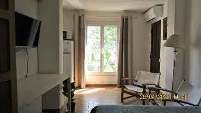 a living room with a large window and a chair at NICE - STUDIO indépendant en VILLA - Mer ville calme jardinet in Nice