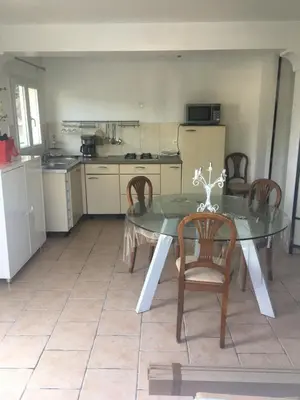 a dining room with a glass table and chairs in a kitchen at Loft 2 in La Trinité