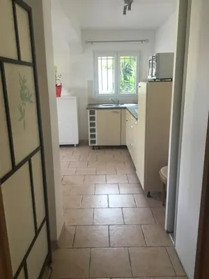 a kitchen with a tile floor and a refrigerator at Loft 2 in La Trinité