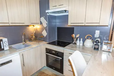 a kitchen with a stove top oven next to a sink at Le Pied Dans L'eau - Parking - Seaside - Hipprodrome in Cagnes-sur-Mer