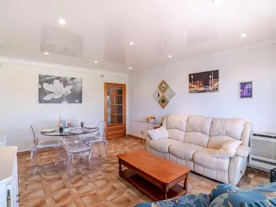 a living room with a couch and a table at Apartment Le Giono by Interhome in Saint-Laurent-du-Var