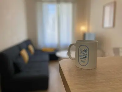 a coffee cup sitting on a table in a living room at Nice Renting - Penchienatti - Spacious Apartment - 2 BedRooms - King Bed - View Heart of Nice in Nice