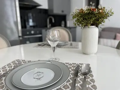a table with a plate and a wine glass on it at Nice Renting - 9 MASSENA - Spacious apartment Massena Square - AC - fully equipped in Nice