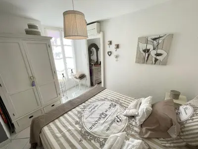 a bedroom with a bed with a striped bedspread at Nice Renting - 9 MASSENA - Spacious apartment Massena Square - AC - fully equipped in Nice