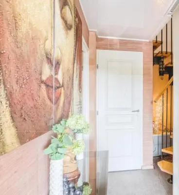 a large painting of a woman on a wall next to a door at Harmonice in Cantaron