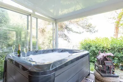 a hot tub in a room with a large window at Harmonice in Cantaron