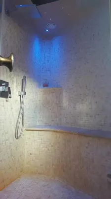 a bathroom with a shower with blue lights on the wall at Harmonice in Cantaron