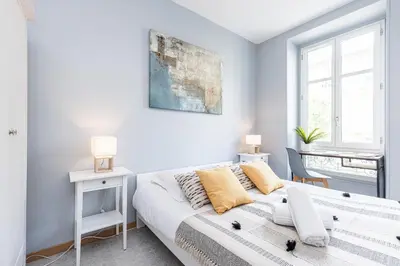 a white bedroom with a bed and a desk at Large 3 Bdr City Center in Nice