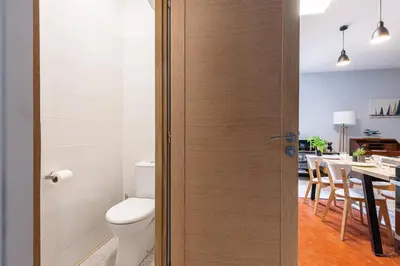 a bathroom with a toilet and a dining room at Large 3 Bdr City Center in Nice