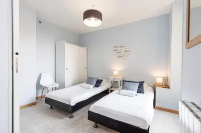 a bedroom with two beds and a chair in it at Large 3 Bdr City Center in Nice