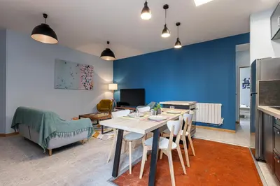 a living room with a table and a blue wall at Large 3 Bdr City Center in Nice