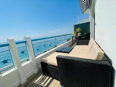 a balcony with a table and chairs and the ocean at SEA VIEW TOP FLOOR - PROMENADE DES ANGLAIS in Nice